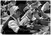 Bai women in tribal dress selling vegetables at the Monday market. Shaping, Yunnan, China ( black and white)