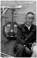 Man selling musical instruments. Shaping, Yunnan, China (black and white)