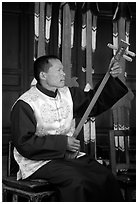 Musician playing a three-stringed traditional moon guitar. Baisha, Yunnan, China ( black and white)