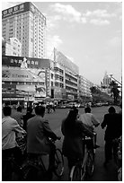 Bicyclists wait for the green light on a modern avenue. Kunming, Yunnan, China (black and white)