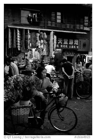 Flower peddler in an old alley. Kunming, Yunnan, China (black and white)