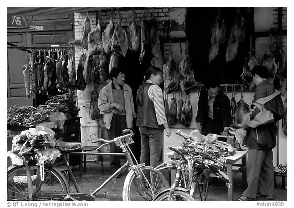 Loading roasted meat on a bicycle. Kunming, Yunnan, China (black and white)
