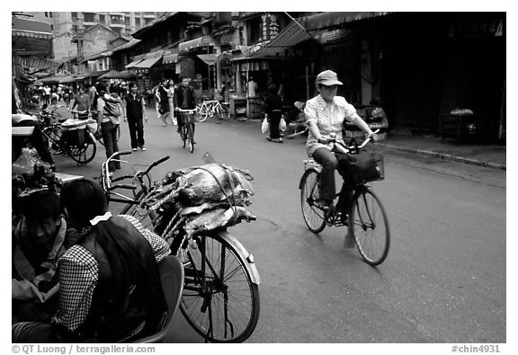 Woman on bicycle in an old backstreet. Kunming, Yunnan, China (black and white)