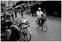 Woman on bicycle in an old backstreet. Kunming, Yunnan, China (black and white)