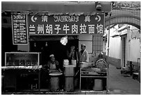 Muslim cooks at restaurant storefront. Kunming, Yunnan, China (black and white)