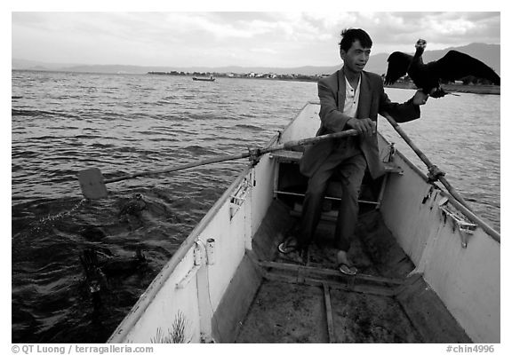 Fisherman holding a cormorant. Dali, Yunnan, China (black and white)