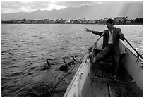 Cormorant Fisherman gives orders to his  fishing birds. Dali, Yunnan, China (black and white)