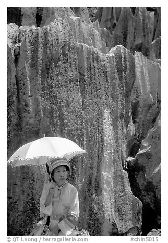 Woman from the Sani branch of the Yi tribespeople with a sun unbrella at the Stone Forest. Shilin, Yunnan, China