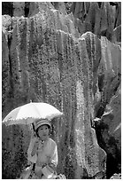 Woman from the Sani branch of the Yi tribespeople with a sun unbrella at the Stone Forest. Shilin, Yunnan, China ( black and white)