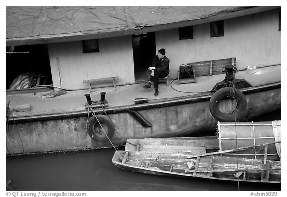 Man sitting on a house boat. Leshan, Sichuan, China