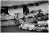 Man sitting on a house boat. Leshan, Sichuan, China (black and white)