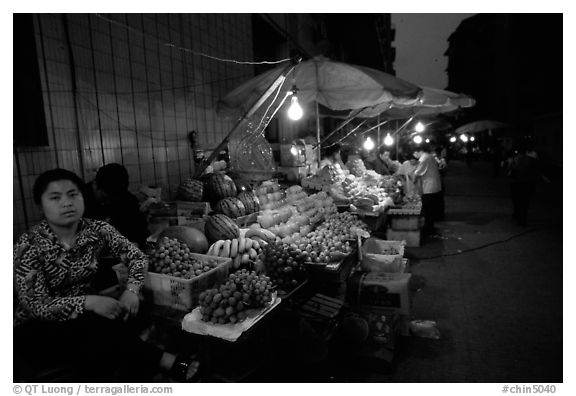 Fruit vendor, night market. Leshan, Sichuan, China (black and white)