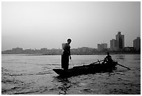 Fishermen at the confluence of the Dadu He and Min He rivers at sunset. Leshan, Sichuan, China (black and white)