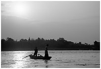 Fishermen at the confluence of the Dadu He and Min He rivers at sunset. Leshan, Sichuan, China (black and white)