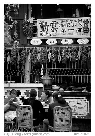 Women eat outside the Snack Food in Lijiang restaurant. Lijiang, Yunnan, China (black and white)
