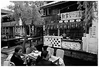 Women eat outside the Snack Food in Lijiang restaurant. Lijiang, Yunnan, China (black and white)