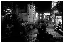Red lanterns reflected in a canal at night. Lijiang, Yunnan, China ( black and white)