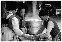 Naxi Women preparing the baba flatbreat. Lijiang, Yunnan, China (black and white)