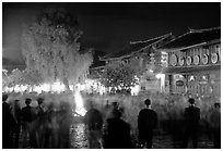 Celebration around a fire in Square Street by night. Lijiang, Yunnan, China ( black and white)