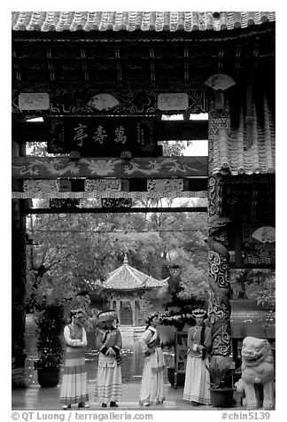Women in Naxi dress standing in an archway. Lijiang, Yunnan, China
