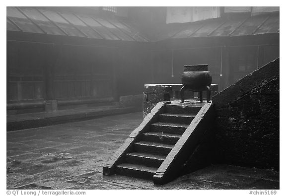 Urn and stairs in courtyard of Xiangfeng temple in fog. Emei Shan, Sichuan, China
