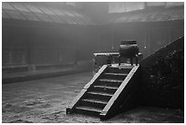 Urn and stairs in courtyard of Xiangfeng temple in fog. Emei Shan, Sichuan, China (black and white)