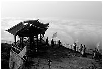 Monks and pilgrims admiring a sea of cloud from the summit. Emei Shan, Sichuan, China ( black and white)