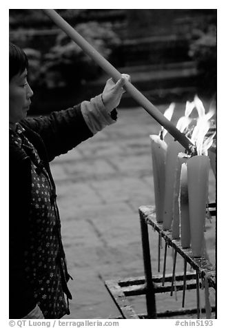 Woman Pilgrim lighting a large incense stick, Wannian Si. Emei Shan, Sichuan, China (black and white)