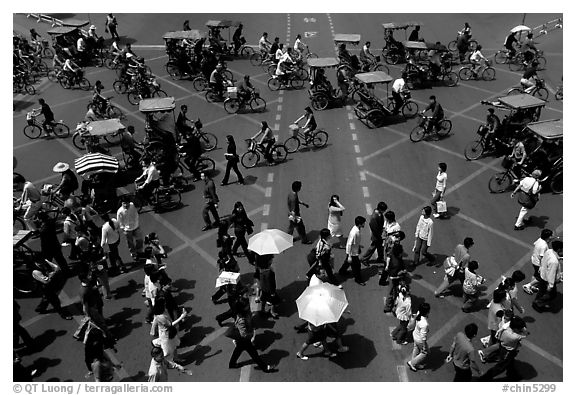 Pedestrians and bicyclists cross a major avenue. Chengdu, Sichuan, China (black and white)