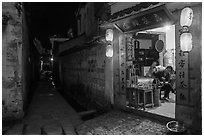 Shopkeeper and alley at night. Hongcun Village, Anhui, China ( black and white)