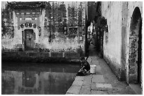 Woman washes laundry in Moon Pond. Hongcun Village, Anhui, China ( black and white)