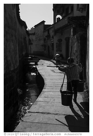 Woman carrying buckets. Xidi Village, Anhui, China (black and white)