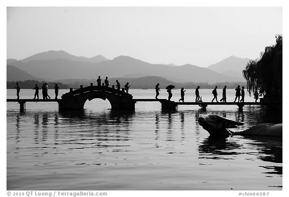 People walking on Yongjin Bridge, West Lake. Hangzhou, China (black and white)