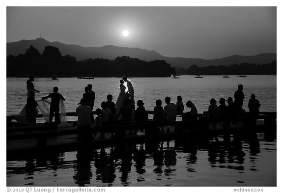 Couple embracing at sunset among crowd, West Lake. Hangzhou, China (black and white)