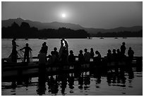 Couple embracing at sunset among crowd, West Lake. Hangzhou, China ( black and white)