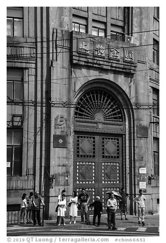 People standing in front of historic bank gate. Shanghai, China (black and white)