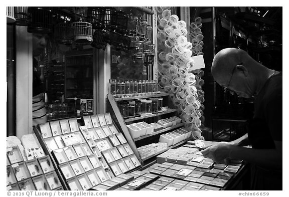 Man shopping at Bird and Insect Market. Shanghai, China (black and white)