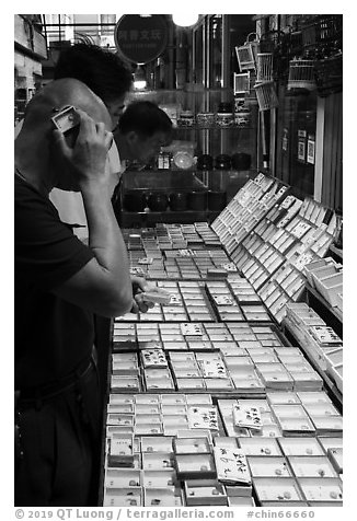 Man listening at insect. Shanghai, China (black and white)