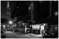 Dark street, store with lanters, and Taipei 101. Taipei, Taiwan (black and white)