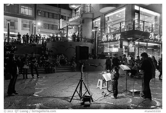 Tourists watch girl singing at night near the pier, Shueishe Village. Sun Moon Lake, Taiwan