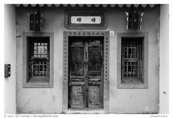 Facade of concrete building with wooden doors and windows. Lukang, Taiwan
