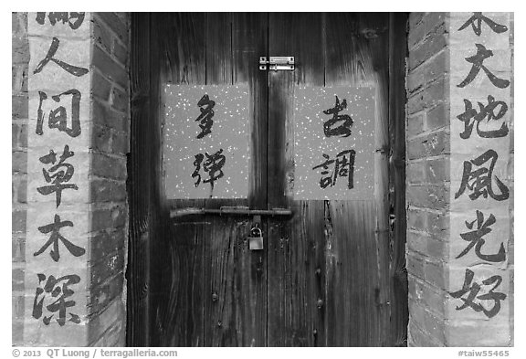 Wooden door and brick wall with Chinese writing. Lukang, Taiwan