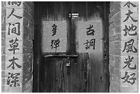 Wooden door and brick wall with Chinese writing. Lukang, Taiwan (black and white)