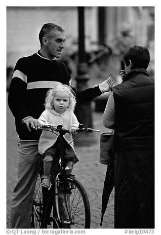 Blond little girl sitting on bicycle. Bruges, Belgium (black and white)