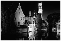 Old houses and beffroi reflected in canal at night. Bruges, Belgium (black and white)