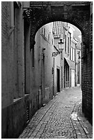 Narrow cobled street and archway. Bruges, Belgium (black and white)
