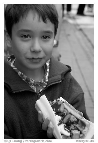 Boy eating a Belgian waffle. Brussels, Belgium (black and white)