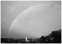 Rainbow over Nesselwang and St Andreas church. Bavaria, Germany (black and white)