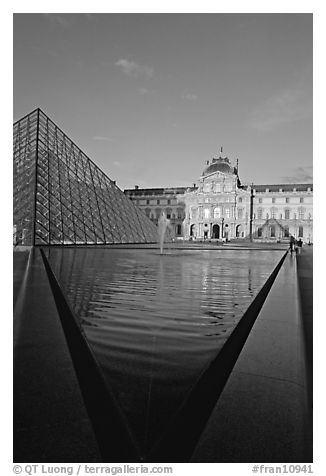 Pyramid and triangular basin in the Louvre, sunset. Paris, France (black and white)