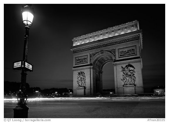 Street lamp and Etoile triumphal arch at night. Paris, France (black and white)